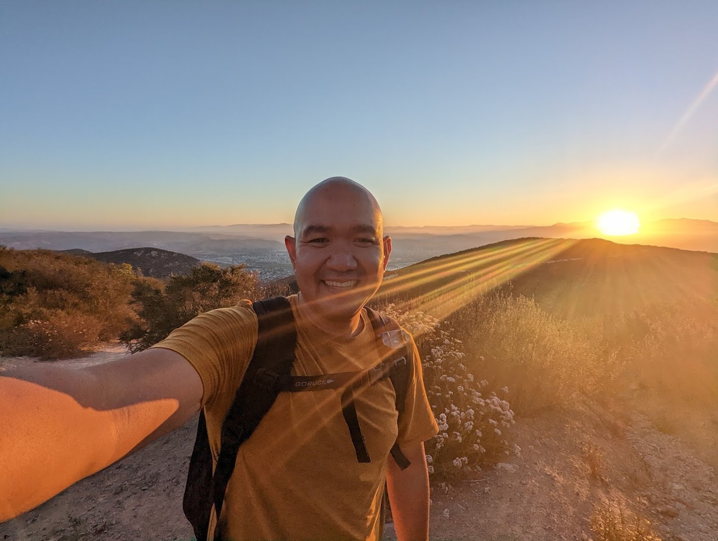 Curtis Yoi on a mountain trail at sunset